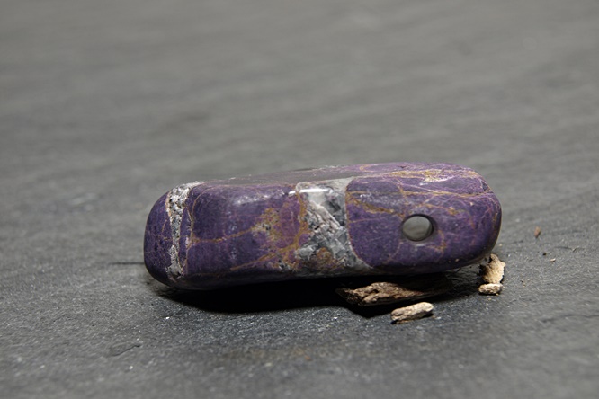 Trommelstein Purpurit. Länglich, ca.3,5 x 1,2 cm, Farbe lila marmoriert
